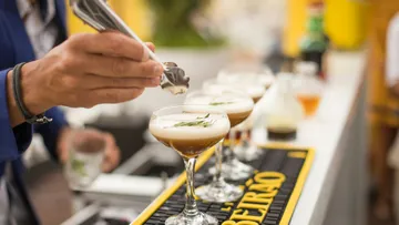 Handgarnieren von Cocktailgläsern an einer Bar.