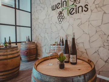 Wine barrel with bottles and glasses in a modern room.