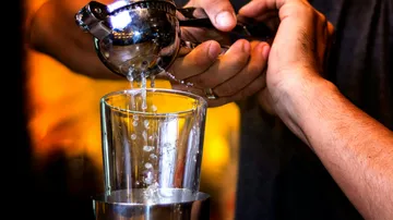 Person, die Zitrusfrüchte in ein Glas presst