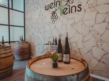 Weinfässer stehen in einem stilvollen Raum mit Weinen.