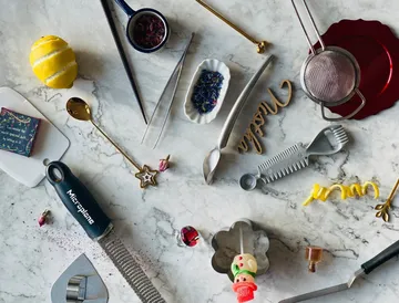 Assorted kitchen tools on marble surface.