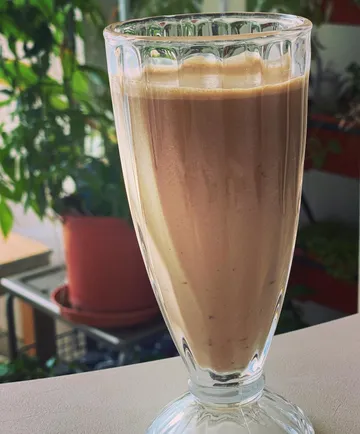 Glas Smoothie mit Pflanzen-Hintergrund.