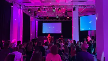 People gathered at event with purple lighting.