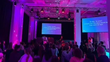 Publikum im Nachtclub mit projizierten Liedtexten.