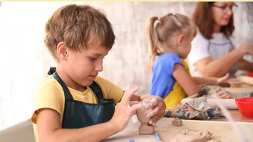 Kinder formen Ton im Kunstunterricht.