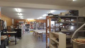 Workshop room with tables and shelves filled with materials.
