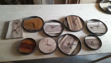Handmade wooden clocks on a table.