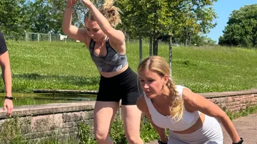Zwei Frauen, die an einem sonnigen Tag im Freien trainieren.