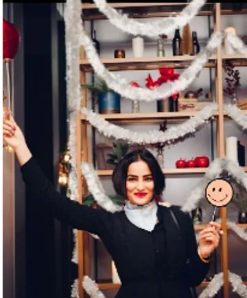 Woman smiling with party decorations background.