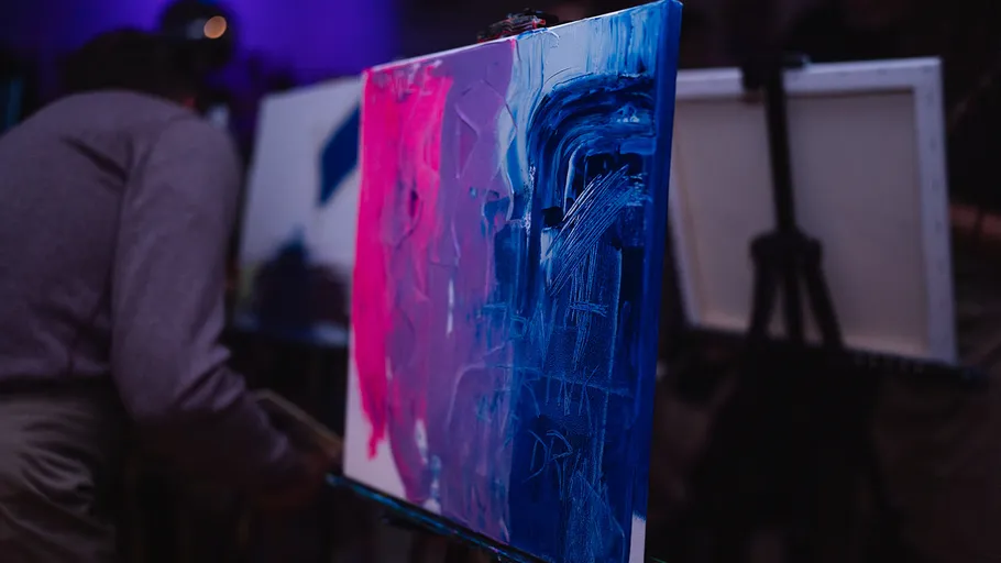 Abstract painting in pink and blue on easel.