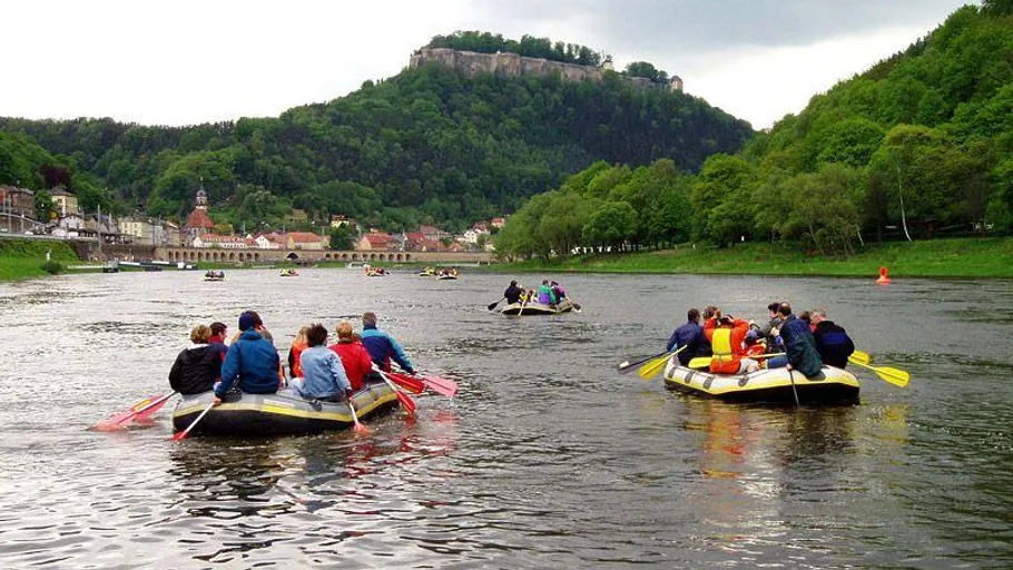 Leute raften auf einem Fluss in der Nähe von Bergen.