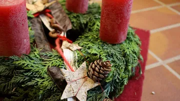 Festive wreath with red candles and pinecones