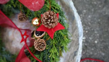 Christmas wreath with pinecones and red decorations.