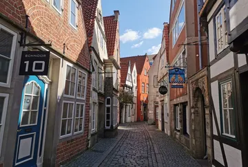 Narrow cobblestone street with old brick buildings.