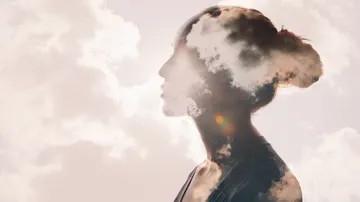 Doppelbelichtung des Profils einer Frau mit Wolken.