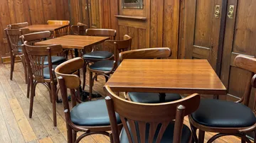 Wooden tables and chairs in cozy cafe.