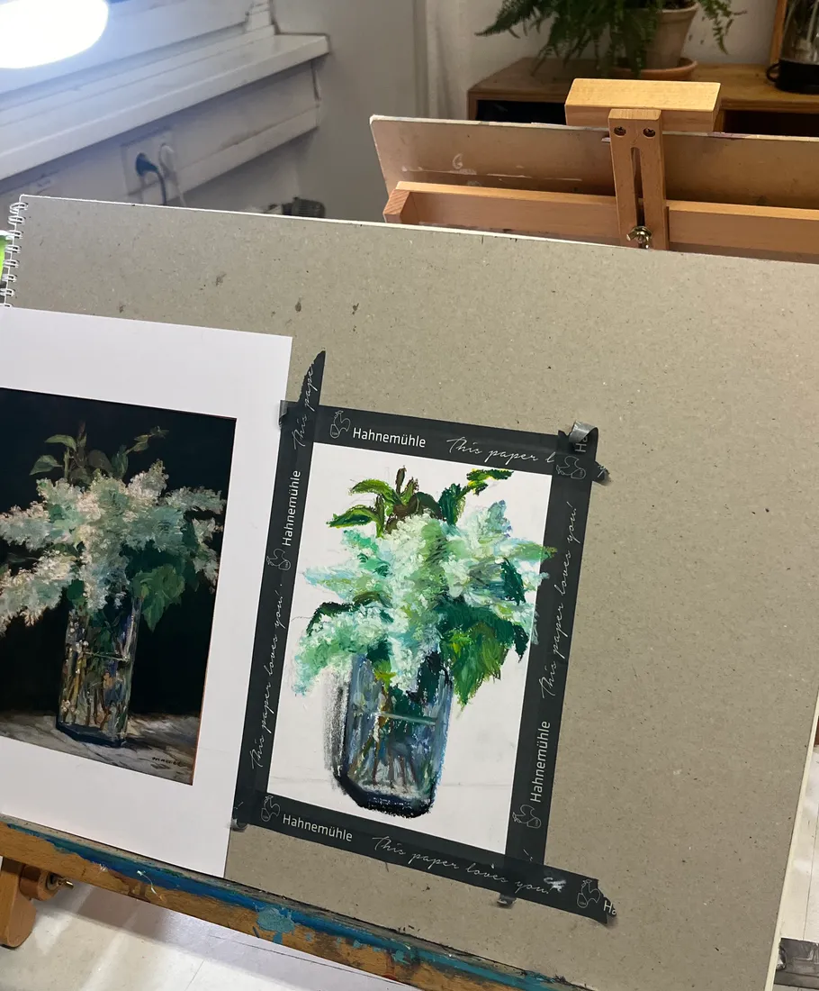 Zwei Blumenbilder in einer Vase auf einer Staffelei.