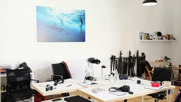 Photography studio with cameras and equipment on desks.