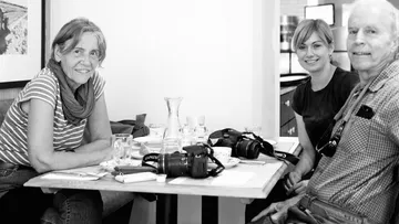Three people seated at a table with cameras.