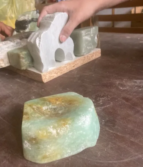 Hand haltend gemeißelten Stein, gedeckter Tisch.