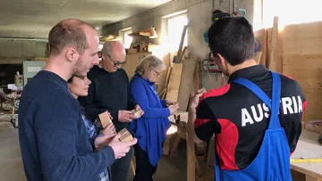 Leute, die Holzstücke in einer Werkstatt inspizieren.