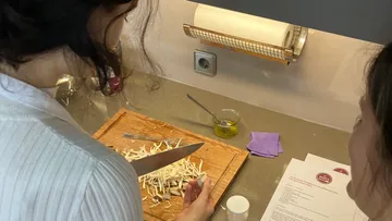 Person chopping vegetables on a wooden board.