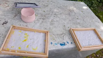 Rahmen für die Papierherstellung mit Zellstoff auf dem Tisch im Freien.