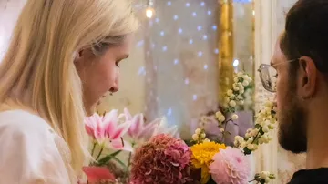 People arranging colorful flowers indoors