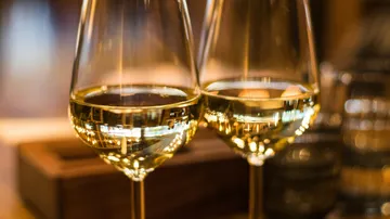 Zwei Weingläser gefüllt mit Weißwein.