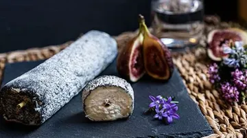Ziegenkäse mit Holzkohleüberzug und Feigen auf Schiefer.