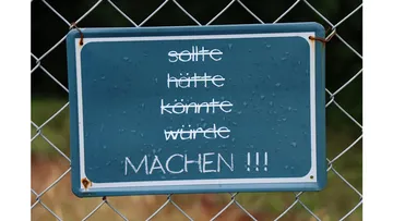Sign with German text on fence.