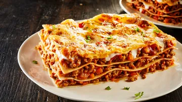 Lasagna slice with meat sauce on plate.