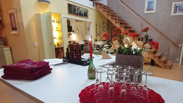 Essbereich mit Gläsern, Blumen, Treppe.