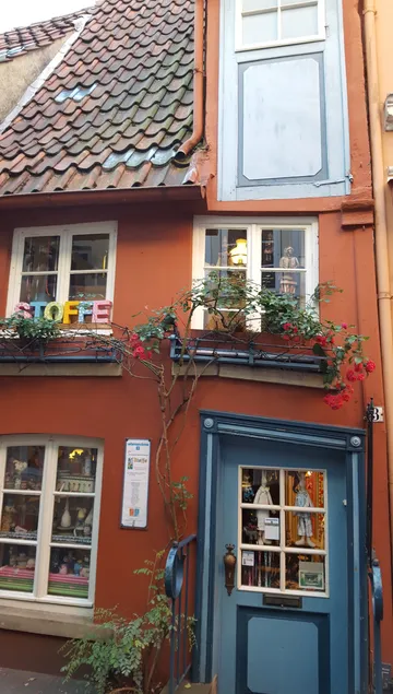 Colorful house with mannequins in windows.
