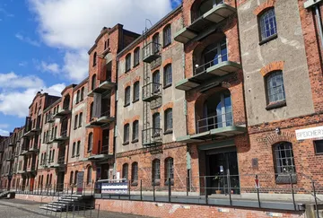 Old brick warehouse building with balconies.