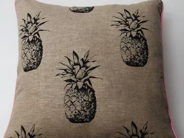 Pineapple pattern cushion on brown fabric background.