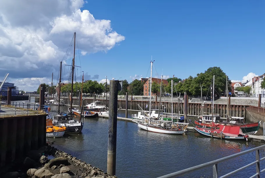Sailboats moored in a sunny harbor.
