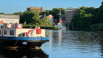 Boat on river with buildings and trees