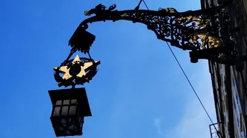 Prunkvolle Straßenlaterne vor blauem Himmel.