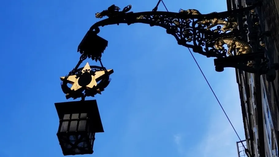 Prunkvolle Straßenlaterne vor blauem Himmel.