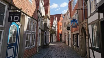 Narrow cobblestone street with half-timbered houses.