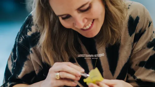 Person, die ein Objekt mit Fokus und Freude malt.