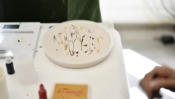 Paint swirl pattern on circular plate, indoors.