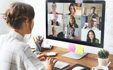 Person participating in a video conference on a desktop.