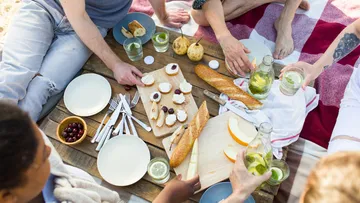 Gruppe beim Picknick mit Brot und Getränken