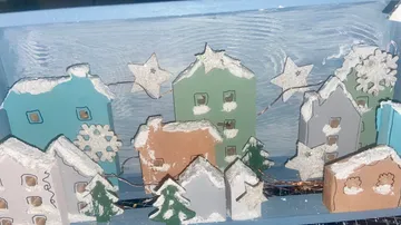Miniature snowy village with star decorations.