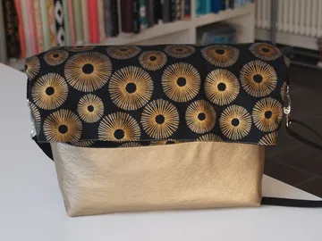 Special bag with gold and black patterns on table.