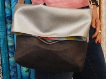 A bag is held by a person, colorful background.
