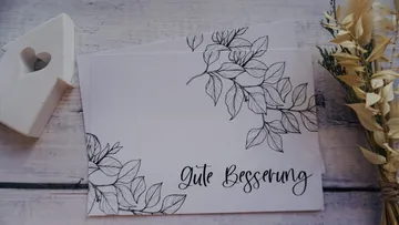 Grußkarte mit Blumenmuster und dem Text „Gute Besserung“.