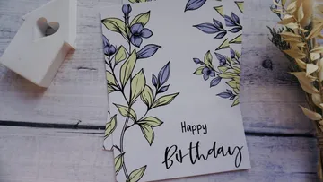 Floral birthday card on wooden surface.